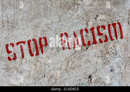Stencil stop racism on an old concrete wall. Background. Collage. Concept. Stock Photo