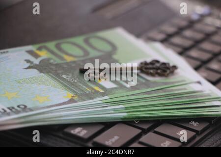 Computer keyboard with euro banknotes on it and vintage key. Key to success concept. Online business concept Stock Photo