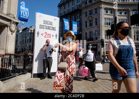 Sign at Oxford Circus reminds pedestrians to adhere to social distancing regulations. London, UK Stock Photo