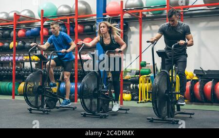 Athletes doing air bike indoor Stock Photo
