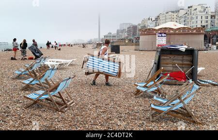 Deck chairs are cleared from the beach in Brighton as thunderstorms and torrential rain are forecast to sweep across the UK, bringing an end to a week of blazing sunshine and scorching temperatures. Stock Photo