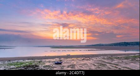 Appledore, North Devon, England. Friday 26th June 2020. UK Weather. After heavy overnight thunderstorms, the coastal villages of Appledore and Instow wake up to a tranquil scene at low tide, as the sun rises over the River Torridge estuary in North Devon. Credit: Terry Mathews/Alamy Live News Stock Photo