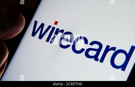 Wirecard payment platform company logo on smartphone and finger pointing at it. Selective focus. Stock Photo