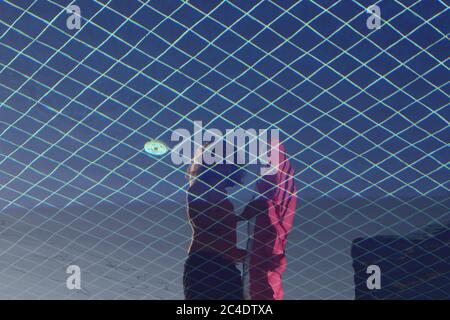 Young Man Holding a Pink Pool Float Reflected in the Water of the Pool Stock Photo