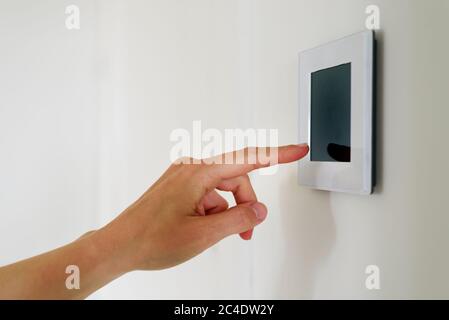 Hand using Air ventilation controller panel with display at home. Smart house system Stock Photo