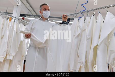 26 June 2020, Saxony, Schreiersgrün: Axel Seidel, managing director of Seidel Moden, shows protective suits being sewn here in his company's ready-to-wear department. The Saxon textile and clothing industry is campaigning for authorities and institutions to increasingly rely on domestic and reusable products as a consequence of the Corona pandemic. Photo: Hendrik Schmidt/dpa-Zentralbild/ZB Stock Photo