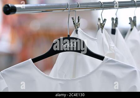 26 June 2020, Saxony, Schreiersgrün: Protective suits are hanging on a clothes rail in the Seidel Moden ready-made clothing line. The Saxon textile and clothing industry is promoting the fact that authorities and institutions as a consequence of the corona pandemic are increasingly relying on domestic and reusable products. Photo: Hendrik Schmidt/dpa-Zentralbild/dpa Stock Photo