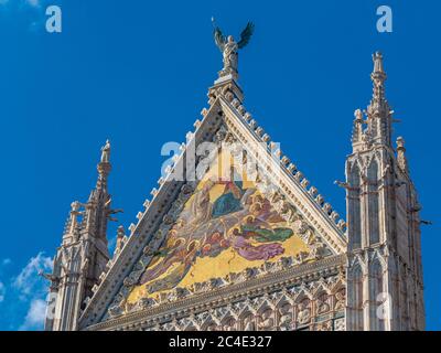 Triangular exterior gable of Siena Cathedral against a blue sky. Siena. Italy. Stock Photo