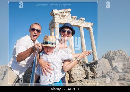 Happy family making a selfie photo using a samrtphone and Selfie stick on summer vacation in Turkey, Side, Manavgat with Temple of Apollo ruines on ba Stock Photo