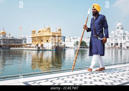 Amritsar, India - AUGUST 16: Holy Guard walking around the Sri Harmandir Sahib or 'Golden Temple' pond Stock Photo