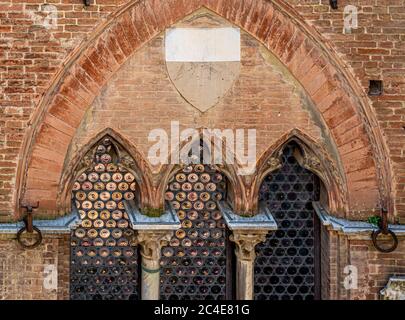 Close up of the brickwork and window of the Palazzo Pubblico seen from the Torre del Mangia. Siena. Italy. Stock Photo