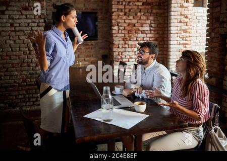 furious cafe owner is arguing with freelancer who ordered two coffees and sitting whole day in cafe Stock Photo