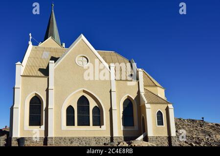 This church is affectionately known as the Felsenkirche or the church on the rocks. It is the highest placed building in the town of Luderitz. Warm ev Stock Photo