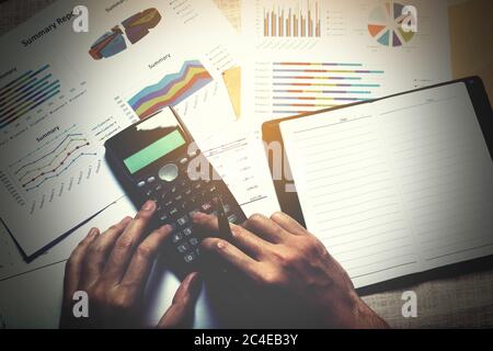 Businessman doing finance and calculate on desk with analyaing summary report at home office. Stock Photo