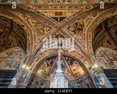 Baptistery ceiling frescoes and baptismal font. Siena Cathedral. Italy. Stock Photo