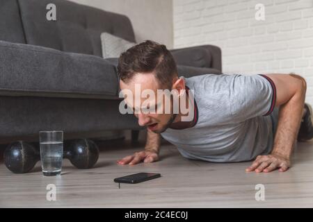 fitness, sport, training and concept - indian man doing push ups at home Stock Photo