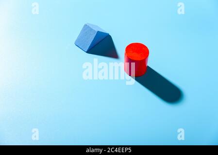 Blue background with red geometric figures casting shadows in a simple composition. Stock Photo