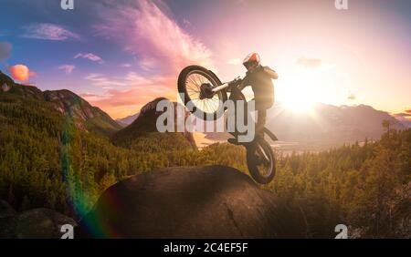Extreme Adventure Man Motorcycle trials on top of a rock Stock Photo