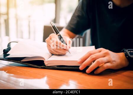 Young asian man hand writing on notebook. Stock Photo