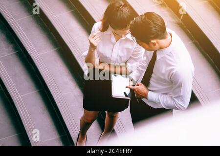 Businessman holding digital tablet and pointing on screen with serious expression. Stock Photo