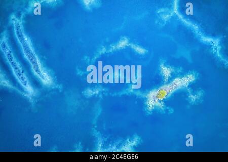 Clear blue colored shallow water surface with tree on smile island. Aerial top view Stock Photo