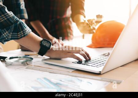 Two architects co-worker working together on project and using laptop checking data about construction. Stock Photo