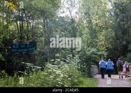 Denham, UK. 26 June, 2020. Metropolitan Police liaison officers walk across a bridge close to a camp created by activists from HS2 Rebellion and Extinction Rebellion UK taking part in a ‘Rebel Trail’ hike along the route of the HS2 high-speed rail link from Birmingham to London. The activists, who departed from Birmingham on 20th June and will arrive outside Parliament in London on 27th June, are protesting against the environmental impact of the high-speed rail link and questioning the viability of the £100bn+ project. Credit: Mark Kerrison/Alamy Live News Stock Photo