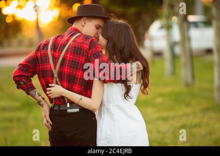 Tender moments. Caucasian young couple enjoying weekend together in the park on summer day. Look lovely, happy, cheerful. Concept of love, relationship, wellness, lifestyle. Sincere emotions. Stock Photo