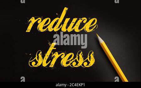 Reduce Stress text written yelllow on black with pencil. Stressfull life crisis management healthcare concept