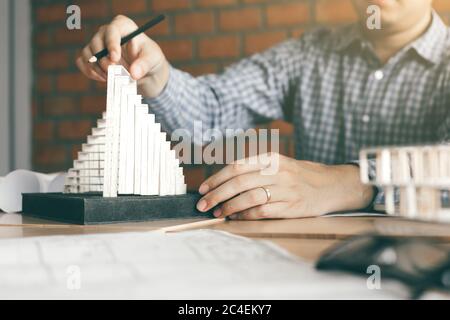 Male engineer using catch modern model in his office. Testing hardness testing of structural strength. Stock Photo