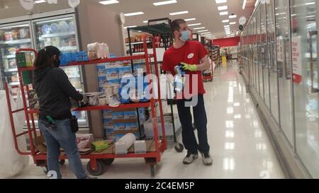 MIDDLETOWN, NY, UNITED STATES - May 29, 2020: Two Target employees stock shelves from their inventory cart while wearing protective faces masks during Stock Photo