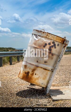 Rusty garbage can on a parking lot in Texas Stock Photo