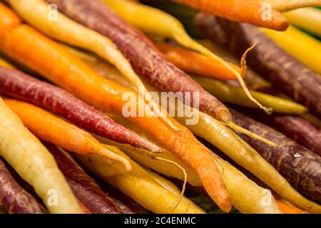 Colourful rainbow carrots for sale on a market  stall Stock Photo