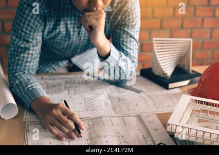 Stress architect man looking blueprint on desk about problem structure interior. Stock Photo