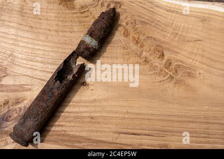 old rusty artillery shell and aircraft projectile on wooden background, shells bullets of world war 2 found, digged out from the ground Stock Photo