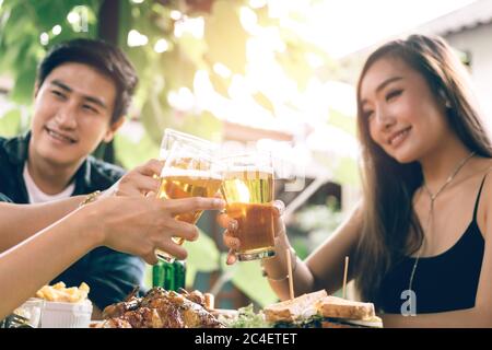 Teeneger asian group of friends clinking glasses in restaurant. Stock Photo
