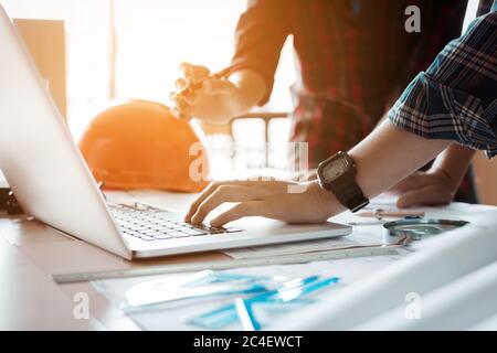 Two architects co-worker working together on project and using laptop checking data at office room. Stock Photo