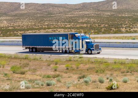 Apple Valley, CA / USA – May 16, 2020: Blue Western Distributing Transportation, Corp, semi-truck on Interstate 15 in the Mojave Desert near the Town Stock Photo