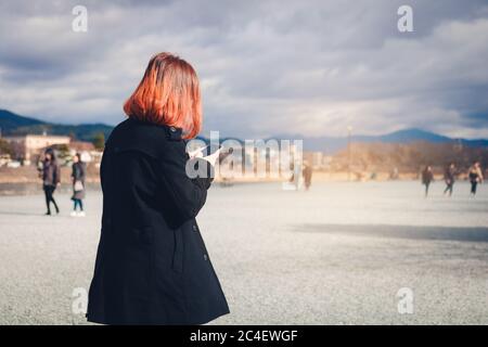 Woman holding a smartphone and is sending a message to someone. Stock Photo