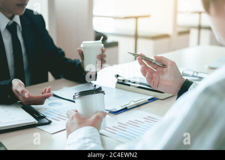 Business people reviewing financial documents and important conversation with colleague. Stock Photo