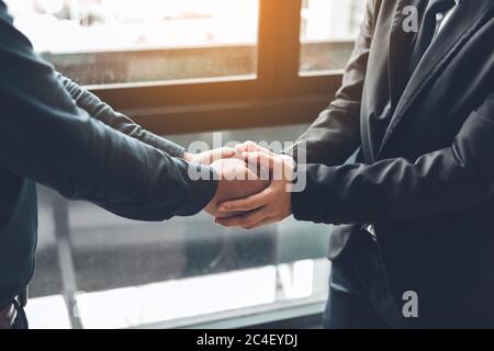 Business people compassionately holding hands at office room. Stock Photo