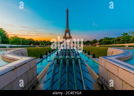 View of the Eiffel Tower at sunrise from the Trocadéro Gardens. Framing the Eiffel Tower are the famous Warsaw fountains. Stock Photo