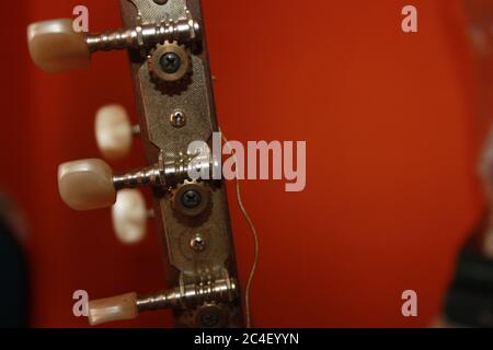 headstock with mechanics of a classical guitar with bright orange background Stock Photo