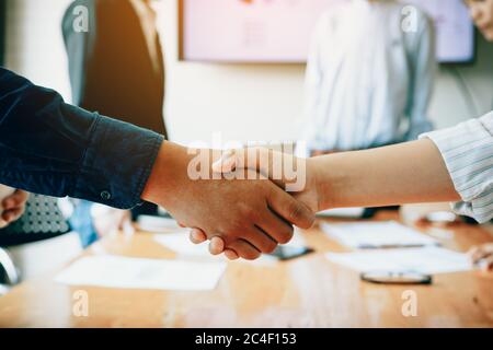Team of entrepreneurs collaborating deal shaking hands in a modern office. Stock Photo