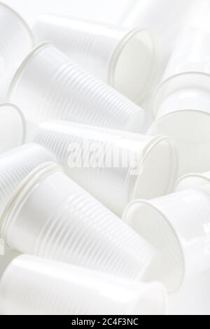 Disposable white plastic cups as background. Environmental concept. Non-compostable waste. Stock Photo