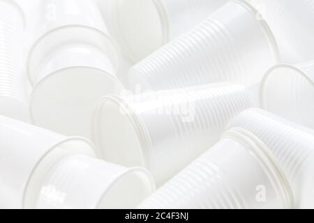 Disposable white plastic cups as background. Environmental concept. Non-compostable waste. Stock Photo