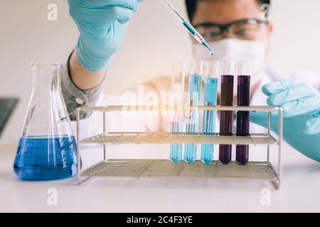 Scientist researching working with chemical fluid with using dropper in a test tube in the laboratory. Stock Photo