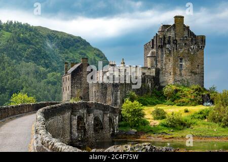 EILEAN DONAN CASTLE LOCH DUICH HIGHLAND SCOTLAND BRIDGE TO THE CASTLE  AFTER SUMMER DOWNPOUR OF RAIN AND THUNDER MIST ON THE HILL Stock Photo