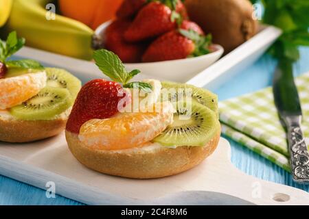 Healthy breakfast fruits and ricotta sandwiches- with strawberries, kiwi and orange. Stock Photo