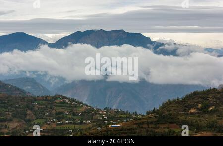 A beautiful, scenic view of the clouds floating through the mountains surrounding the town of Tansen in Nepal. Stock Photo